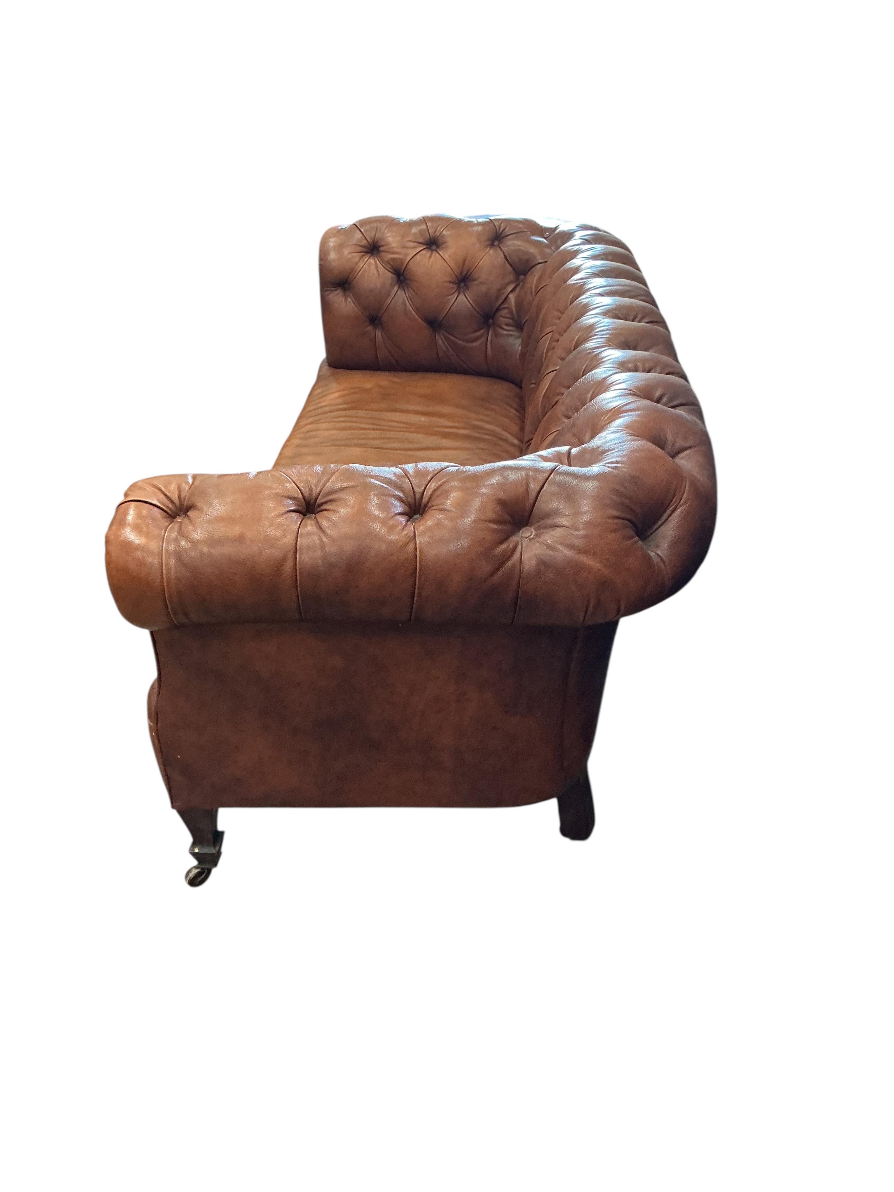 An early 20th century buttoned brown leather Chesterfield settee, width 180cm, depth 78cm, height 71cm
